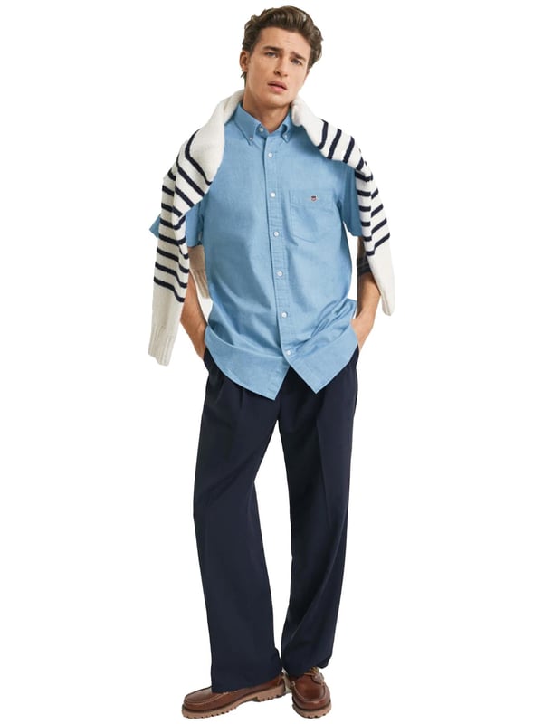 Clásica y versátil, la camisa Oxford es una prenda esencial de estilo smart-casual confeccionada en algodón resistente. Diseñada con corte regular y mangas cortas, es perfecta para los meses más cálidos. Sus detalles incluyen un cuello abotonado, bajo curvado, bolsillo en el pecho con bordado de escudo y una tabla en la espalda con presilla para mayor comodidad y estilo.