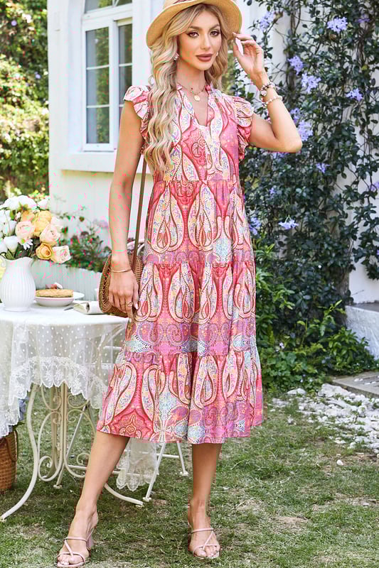 Elegante vestido midi con vibrante estampado tribal de paisley floral  
Mangas con volantes para un toque juguetón y femenino  
Escote en forma de pico para un detalle moderno y sofisticado  
Tejido suave y fluido para comodidad y libertad de movimiento  
Material: 84% Viscosa 16% Poliamida