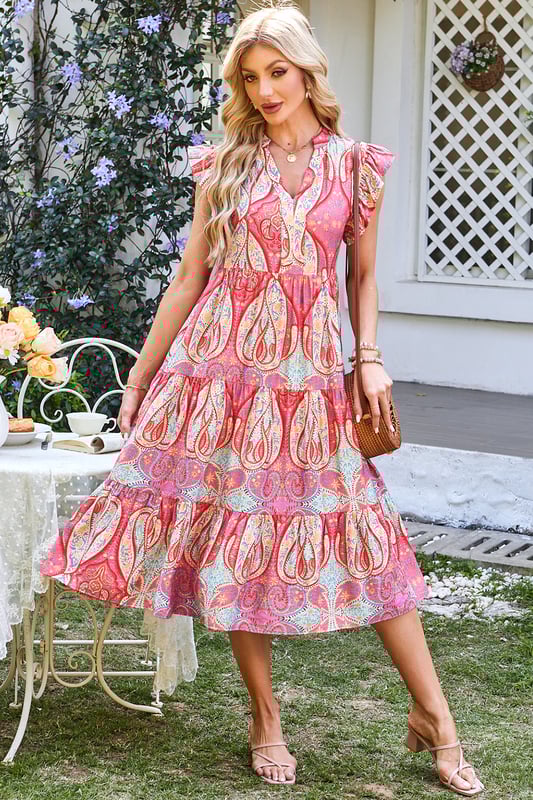 Elegante vestido midi con vibrante estampado tribal de paisley floral  
Mangas con volantes para un toque juguetón y femenino  
Escote en forma de pico para un detalle moderno y sofisticado  
Tejido suave y fluido para comodidad y libertad de movimiento  
Material: 84% Viscosa 16% Poliamida