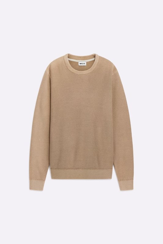El jersey de cuello redondo para hombre, confeccionado en hilo de algodón, revela su carácter versátil al combinar practicidad y estilo, gracias a un patrón de punto de palomitas.  Características principales:  Cálido jersey de algodón de galga 5 con punto palomita Corte regular Tratamiento de lavado al ácido suave y personalizado Etiqueta con logotipo aplicada en la parte delantera inferior izquierda