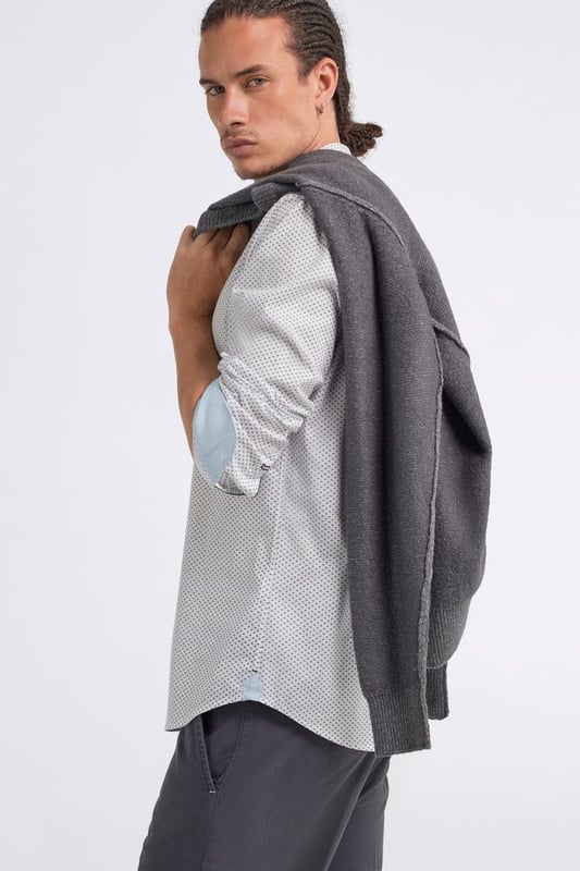 Un aspecto limpio y la atención a los detalles hacen de ella una de las piezas más versátiles del armario. La camisa de popelina elástica para hombre presenta un corte minimalista y detalles refinados, como el micropatrón y los ribetes internos en el cuello y los puños, que añaden un toque de estilo incluso a los looks más informales.   Características principales:  Popelina elástica Corte entallado Cierre con botones Ribete interior en cuello y puños Logotipo en el puño