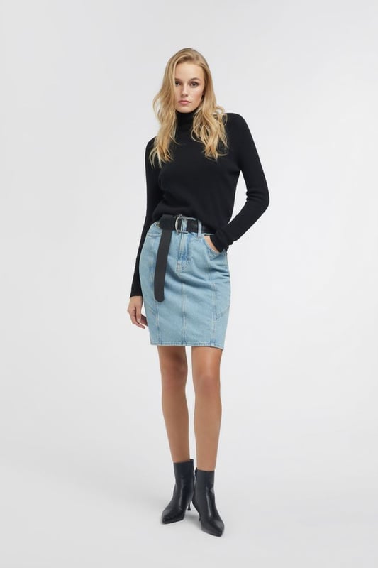 Una falda vaquera midi de talle alto inspirada en los años 90. Adecuada tanto para el día como para la noche, puede combinarse con una camiseta o una camisa oversize para un estilo metropolitano chic y femenino.