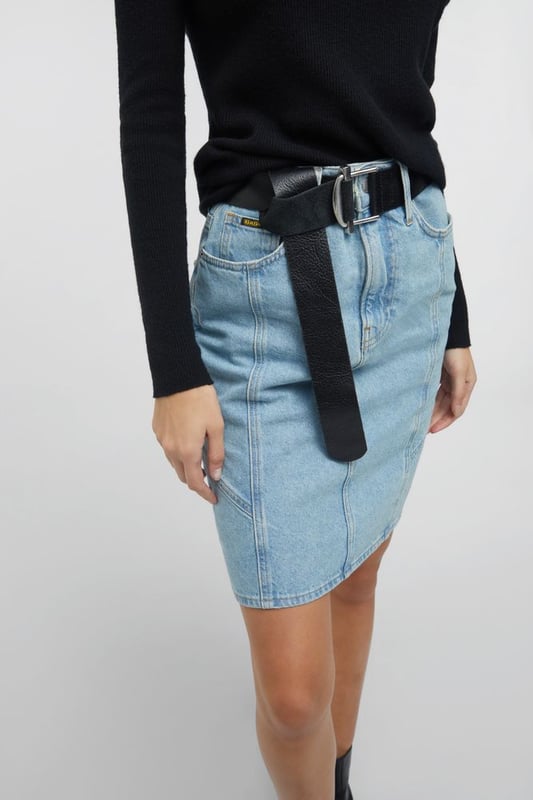Una falda vaquera midi de talle alto inspirada en los años 90. Adecuada tanto para el día como para la noche, puede combinarse con una camiseta o una camisa oversize para un estilo metropolitano chic y femenino.