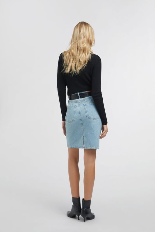Una falda vaquera midi de talle alto inspirada en los años 90. Adecuada tanto para el día como para la noche, puede combinarse con una camiseta o una camisa oversize para un estilo metropolitano chic y femenino.