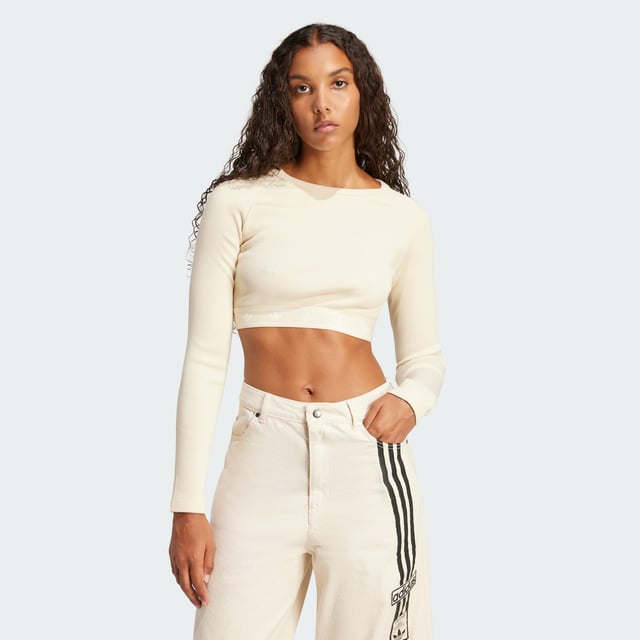 This adidas crop top is inspired by the bold attitudes and style of '90s hip hop. Soft ribbed fabric in a slim silhouette hugs the body while the long sleeves and crewneck give it a casual vibe. It's finished with a repeating Trefoil graphic along the hem.  - Slim fit with crop length - Crewneck - 95% cotton, 5% elastane  Shipped by adidas