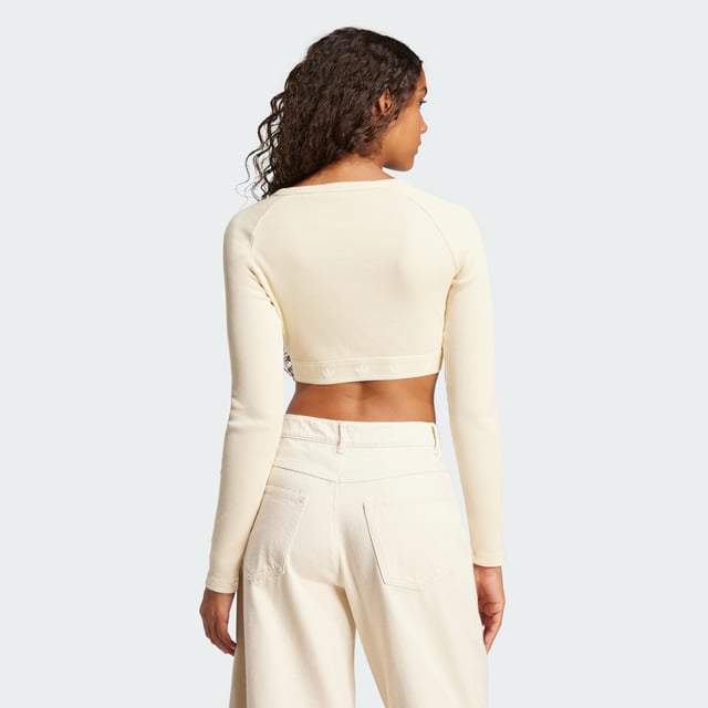 This adidas crop top is inspired by the bold attitudes and style of '90s hip hop. Soft ribbed fabric in a slim silhouette hugs the body while the long sleeves and crewneck give it a casual vibe. It's finished with a repeating Trefoil graphic along the hem.  - Slim fit with crop length - Crewneck - 95% cotton, 5% elastane  Shipped by adidas