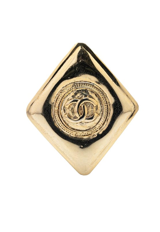This brooch features a gold-tone metal body and a back pin closure.Brand: Chanel VintageCondition: PrelovedType: Costume BroochRating: B+Main Material: MetalDimensions (LxWxD): 4.7x4x0Comments: Lock Scratched. Exterior Front Scratched.