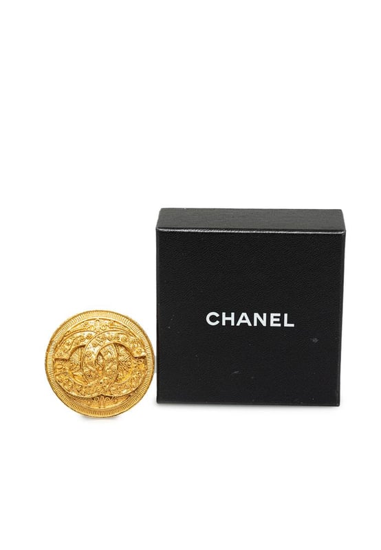 Pre-owned Chanel Brooch Gold Coin Design This brooch features a gold-tone metal body and a back pin closure.Brand: Chanel VintageCondition: PrelovedType: Costume BroochRating: ABMain Material: MetalDimensions (LxWxD): 4.5x4.5x0Comments: Exterior Back Scratched. Lock Rusty/Tarnished Scratched. Exterior Front Discolored Scratched.