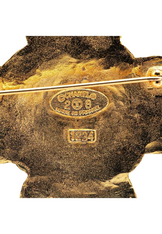 This brooch features a gold-tone metal body and a back pin closure.Brand: Chanel VintageCondition: PrelovedType: Costume BroochRating: B+Main Material: MetalDimensions (LxWxD): 6x5.2x0Comments: Exterior Back Discolored Scratched. Lock Scratched. Exterior Front Scratched.
