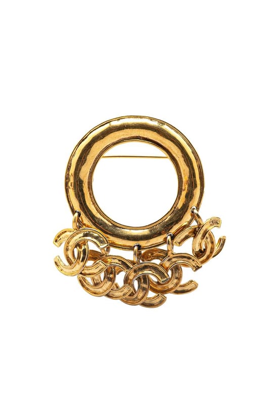 This brooch features a gold-tone metal body CC charms and a back pin closure.Brand: Chanel VintageCondition: PrelovedType: Costume BroochRating: B+Main Material: MetalDimensions (LxWxD): 6.5x8x0Comments: Exterior Back Scratched. Lock Rusty/Tarnished Scratched. Exterior Front Discolored Scratched.