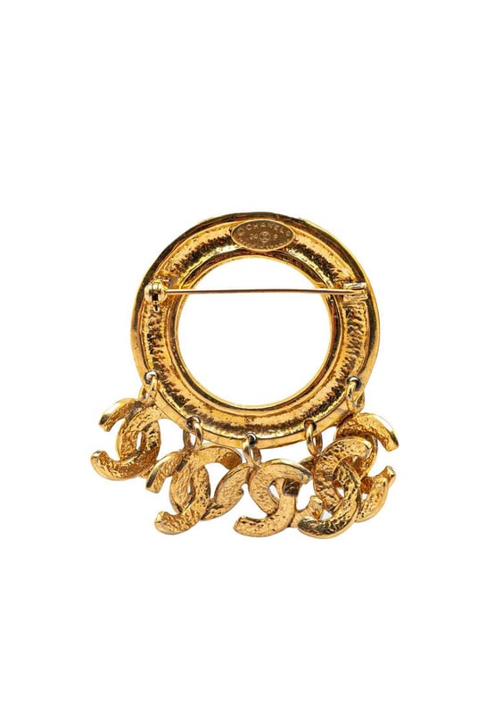 This brooch features a gold-tone metal body CC charms and a back pin closure.Brand: Chanel VintageCondition: PrelovedType: Costume BroochRating: B+Main Material: MetalDimensions (LxWxD): 6.5x8x0Comments: Exterior Back Scratched. Lock Rusty/Tarnished Scratched. Exterior Front Discolored Scratched.