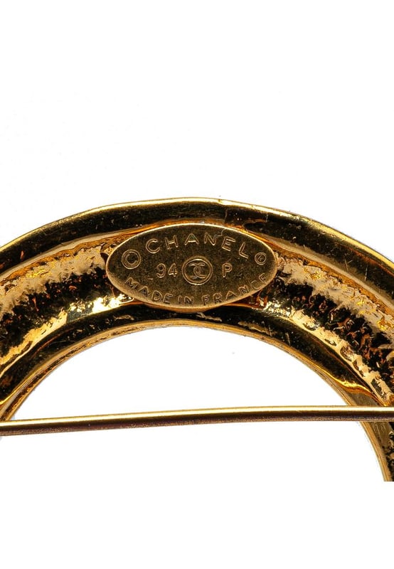 This brooch features a gold-tone metal body CC charms and a back pin closure.Brand: Chanel VintageCondition: PrelovedType: Costume BroochRating: B+Main Material: MetalDimensions (LxWxD): 6.5x8x0Comments: Exterior Back Scratched. Lock Rusty/Tarnished Scratched. Exterior Front Discolored Scratched.