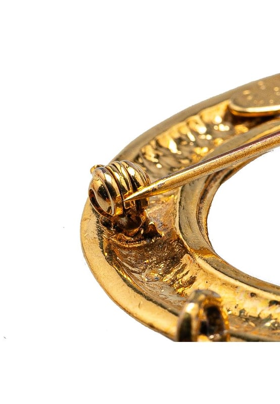 This brooch features a gold-tone metal body CC charms and a back pin closure.Brand: Chanel VintageCondition: PrelovedType: Costume BroochRating: B+Main Material: MetalDimensions (LxWxD): 6.5x8x0Comments: Exterior Back Scratched. Lock Rusty/Tarnished Scratched. Exterior Front Discolored Scratched.