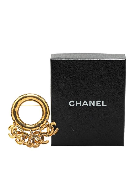 This brooch features a gold-tone metal body CC charms and a back pin closure.Brand: Chanel VintageCondition: PrelovedType: Costume BroochRating: B+Main Material: MetalDimensions (LxWxD): 6.5x8x0Comments: Exterior Back Scratched. Lock Rusty/Tarnished Scratched. Exterior Front Discolored Scratched.