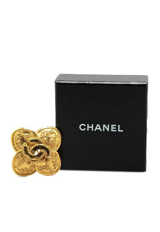 This brooch features a gold-tone metal body and a back pin closure.Brand: Chanel VintageCondition: PrelovedType: Costume BroochRating: B+Main Material: MetalDimensions (LxWxD): 4x4x0Comments: Exterior Back Scratched. Lock Scratched. Exterior Front Scratched.