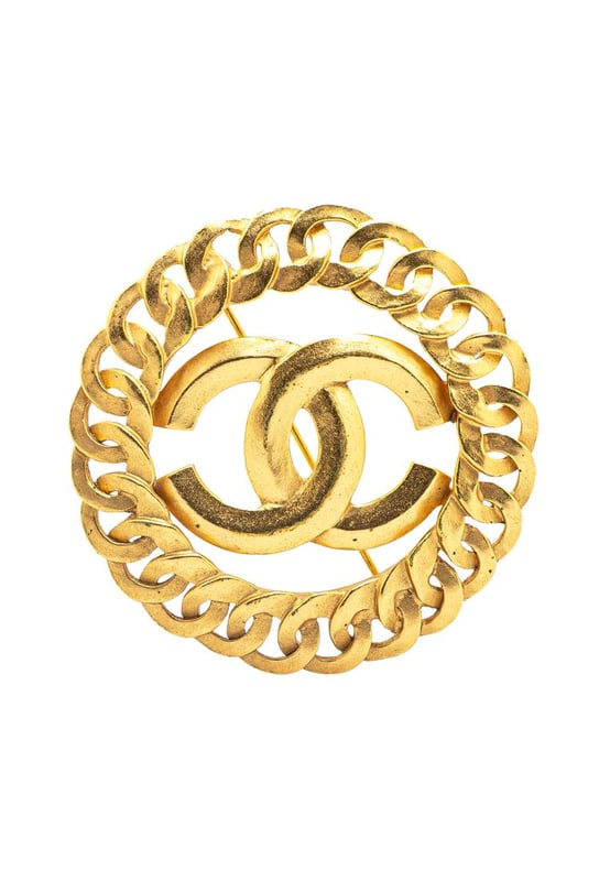 This brooch features a gold-tone metal body and a back pin closure.Brand: Chanel VintageCondition: PrelovedType: Costume BroochRating: ABMain Material: MetalDimensions (LxWxD): 5.5x5.5x0Comments: Exterior Back Discolored Scratched. Lock Scratched. Exterior Front Discolored Scratched.
