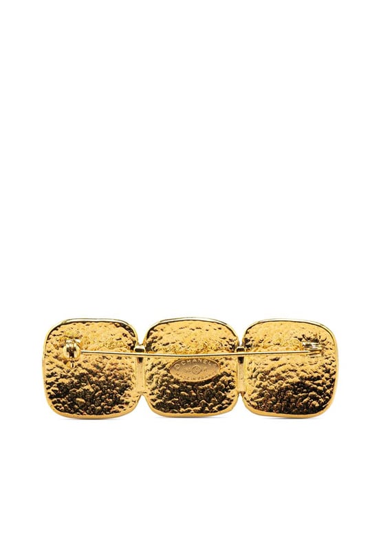 This brooch features a gold-tone metal body and a back pin closure.Brand: Chanel VintageCondition: PrelovedType: Costume BroochRating: B+Main Material: MetalDimensions (LxWxD): 2.3x7x0Comments: Exterior Back Scratched. Lock Scratched. Exterior Front Scratched.