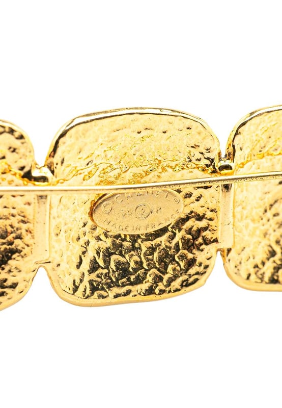 This brooch features a gold-tone metal body and a back pin closure.Brand: Chanel VintageCondition: PrelovedType: Costume BroochRating: B+Main Material: MetalDimensions (LxWxD): 2.3x7x0Comments: Exterior Back Scratched. Lock Scratched. Exterior Front Scratched.