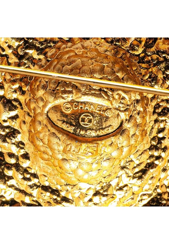 This brooch features a gold-plated metal body and back pin closure.Brand: Chanel VintageCondition: PrelovedType: Costume BroochRating: B+Main Material: MetalDimensions (LxWxD): 5.2x4.9x0Comments: Exterior Back Scratched. Lock Scratched. Exterior Front Scratched.