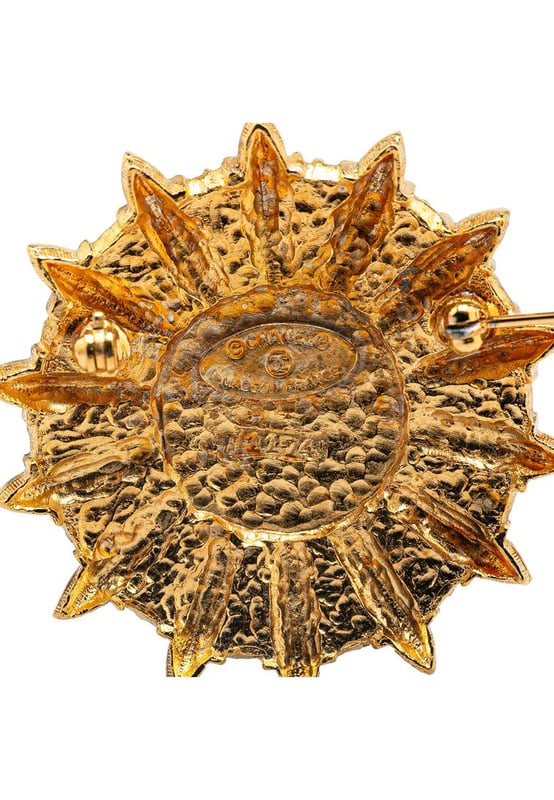 This brooch features a gold-plated metal body and back pin closure.Brand: Chanel VintageCondition: PrelovedType: Costume BroochRating: ABMain Material: MetalDimensions (LxWxD): 4.7x4.6x0Comments: Exterior Back Scratched. Exterior Back stained with Other. Lock Scratched. Exterior Front Scratched. Exterior Front stained with Other.