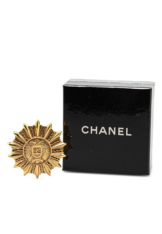 This brooch features a gold-plated metal body and back pin closure.Brand: Chanel VintageCondition: PrelovedType: Costume BroochRating: ABMain Material: MetalDimensions (LxWxD): 4.7x4.6x0Comments: Exterior Back Scratched. Exterior Back stained with Other. Lock Scratched. Exterior Front Scratched. Exterior Front stained with Other.