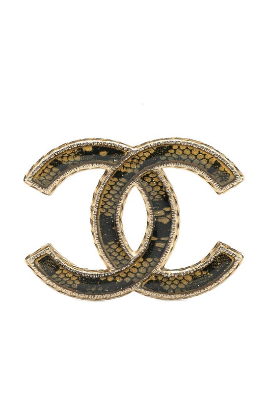 This brooch features a resin body and a back pin closure.Brand: Chanel VintageCondition: PrelovedType: Costume BroochRating: B+Main Material: PlasticDimensions (LxWxD): 3.7x5x0Comments: Exterior Back Scratched. Lock Scratched. Exterior Front Scratched.