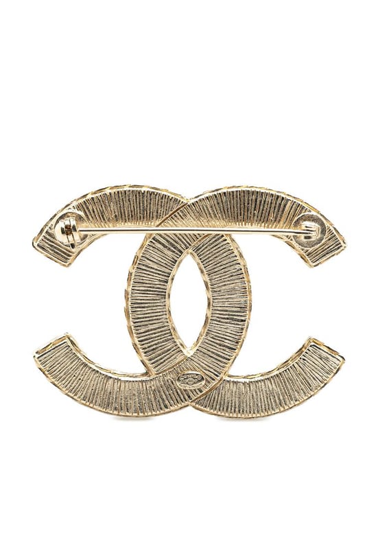 This brooch features a resin body and a back pin closure.Brand: Chanel VintageCondition: PrelovedType: Costume BroochRating: B+Main Material: PlasticDimensions (LxWxD): 3.7x5x0Comments: Exterior Back Scratched. Lock Scratched. Exterior Front Scratched.