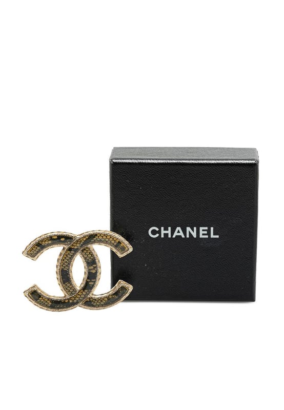 This brooch features a resin body and a back pin closure.Brand: Chanel VintageCondition: PrelovedType: Costume BroochRating: B+Main Material: PlasticDimensions (LxWxD): 3.7x5x0Comments: Exterior Back Scratched. Lock Scratched. Exterior Front Scratched.