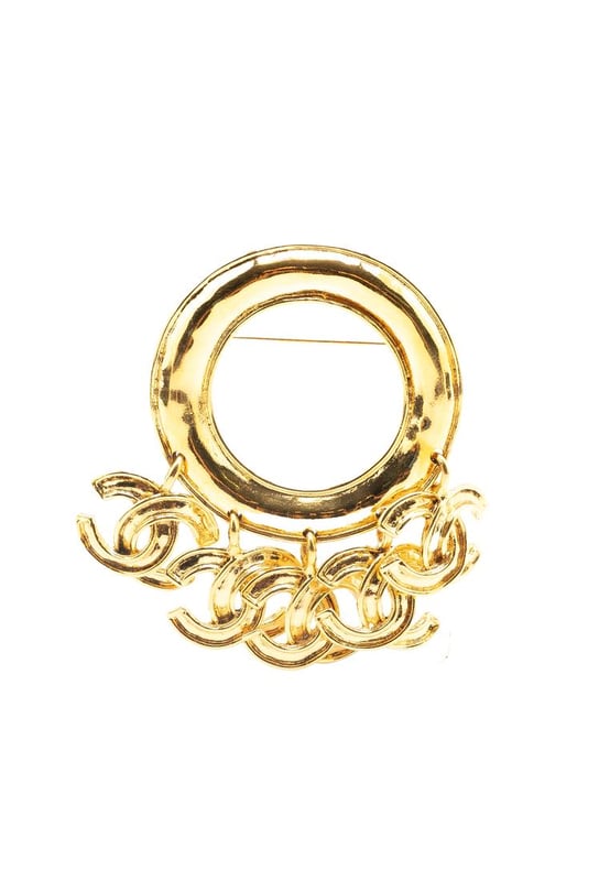 This brooch features a gold-tone metal body CC charms and a back pin closure.Brand: Chanel VintageCondition: PrelovedType: Costume BroochRating: B+Main Material: MetalDimensions (LxWxD): 6.5x7.5x0Comments: Exterior Back Discolored Scratched. Lock Scratched. Exterior Front Scratched.