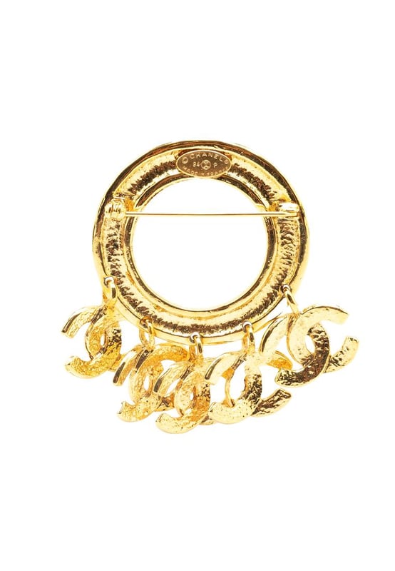 This brooch features a gold-tone metal body CC charms and a back pin closure.Brand: Chanel VintageCondition: PrelovedType: Costume BroochRating: B+Main Material: MetalDimensions (LxWxD): 6.5x7.5x0Comments: Exterior Back Discolored Scratched. Lock Scratched. Exterior Front Scratched.