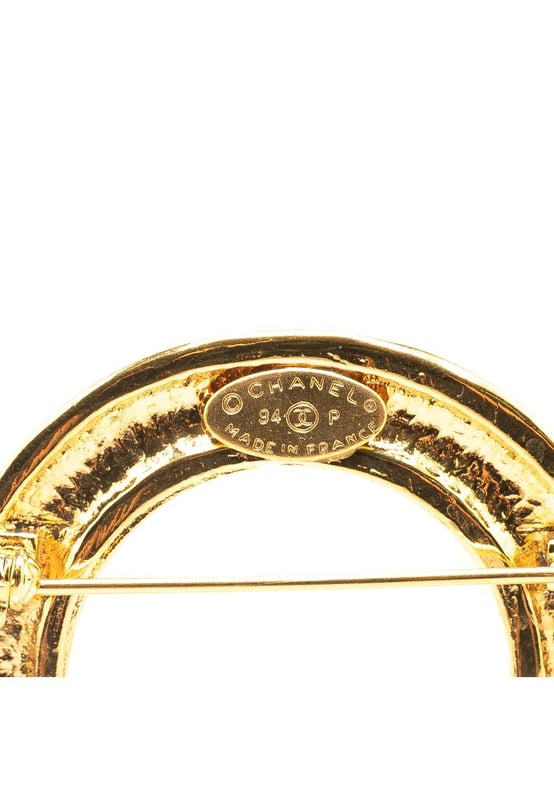 This brooch features a gold-tone metal body CC charms and a back pin closure.Brand: Chanel VintageCondition: PrelovedType: Costume BroochRating: B+Main Material: MetalDimensions (LxWxD): 6.5x7.5x0Comments: Exterior Back Discolored Scratched. Lock Scratched. Exterior Front Scratched.
