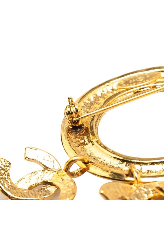 This brooch features a gold-tone metal body CC charms and a back pin closure.Brand: Chanel VintageCondition: PrelovedType: Costume BroochRating: B+Main Material: MetalDimensions (LxWxD): 6.5x7.5x0Comments: Exterior Back Discolored Scratched. Lock Scratched. Exterior Front Scratched.