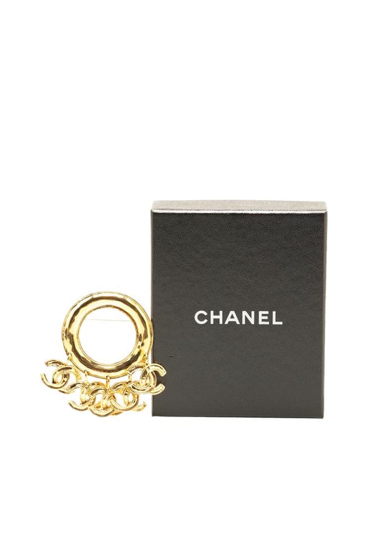 This brooch features a gold-tone metal body CC charms and a back pin closure.Brand: Chanel VintageCondition: PrelovedType: Costume BroochRating: B+Main Material: MetalDimensions (LxWxD): 6.5x7.5x0Comments: Exterior Back Discolored Scratched. Lock Scratched. Exterior Front Scratched.