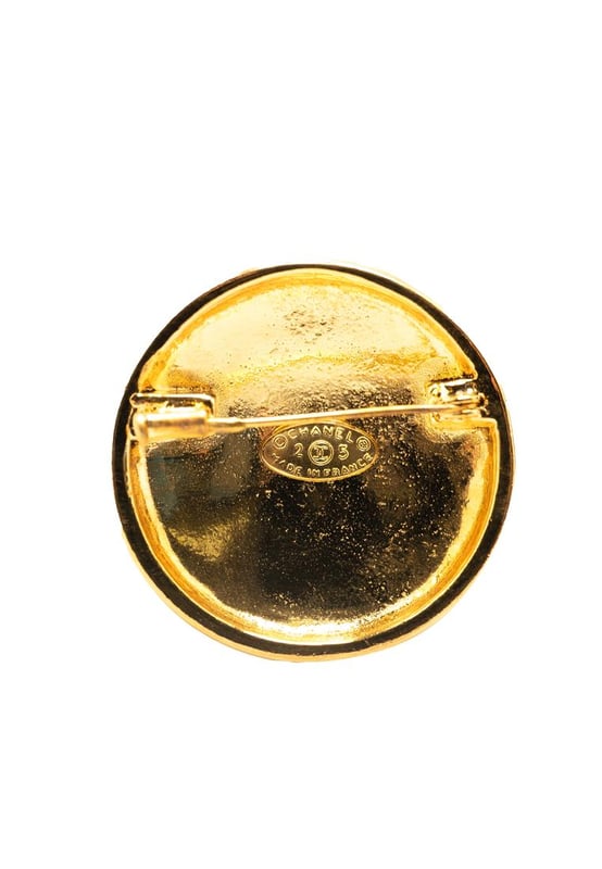 This brooch features a gold-plated metal body and a back pin closure.Brand: Chanel VintageCondition: PrelovedType: Costume BroochRating: B+Main Material: MetalDimensions (LxWxD): 4x4x0Comments: Exterior Back Scratched. Lock Rusty/Tarnished Scratched. Exterior Front Scratched.