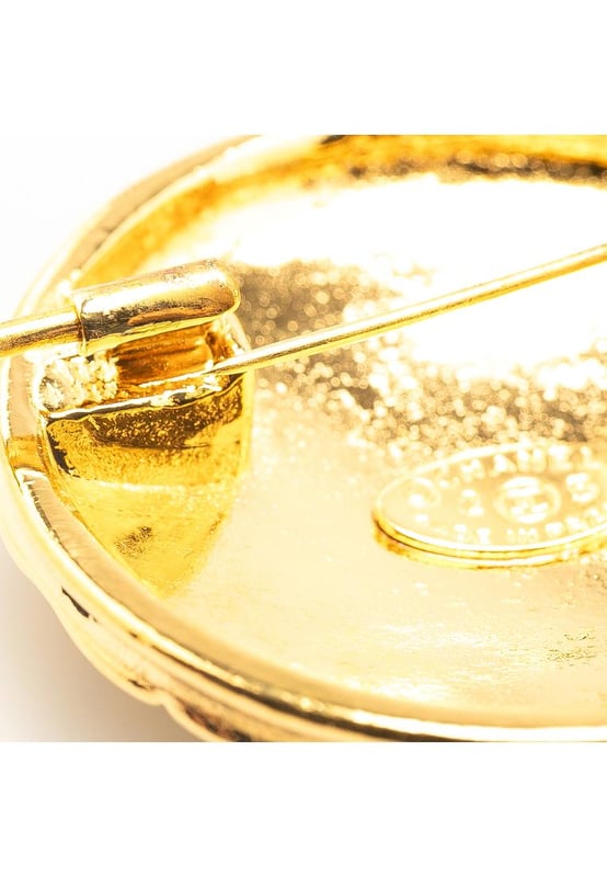 This brooch features a gold-plated metal body and a back pin closure.Brand: Chanel VintageCondition: PrelovedType: Costume BroochRating: B+Main Material: MetalDimensions (LxWxD): 4x4x0Comments: Exterior Back Scratched. Lock Rusty/Tarnished Scratched. Exterior Front Scratched.