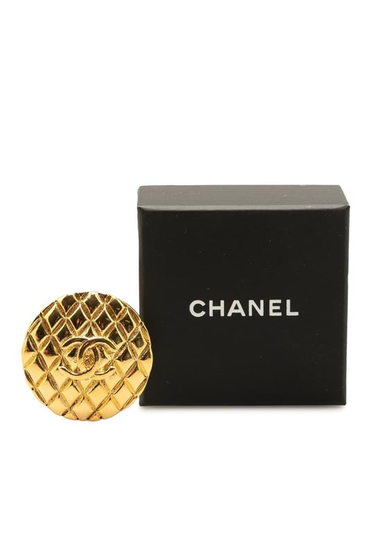 This brooch features a gold-plated metal body and a back pin closure.Brand: Chanel VintageCondition: PrelovedType: Costume BroochRating: B+Main Material: MetalDimensions (LxWxD): 4x4x0Comments: Exterior Back Scratched. Lock Rusty/Tarnished Scratched. Exterior Front Scratched.
