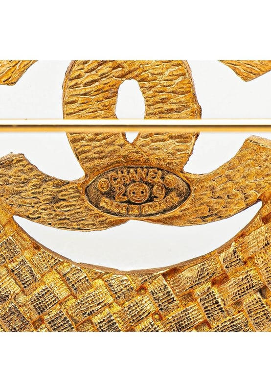 This brooch features a gold-tone metal body and a back pin closure.Brand: Chanel VintageCondition: PrelovedType: Costume BroochRating: B+Main Material: MetalDimensions (LxWxD): 3.6x3.6x0Comments: Exterior Back Discolored Scratched. Lock Scratched.