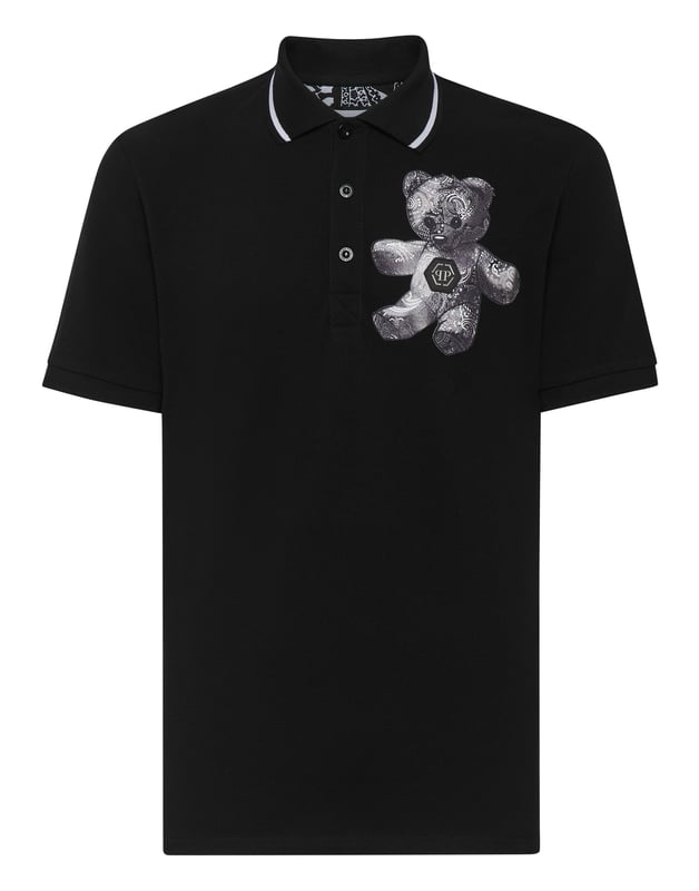 Auch ein Klassiker kann einen alternativen Twist bekommen. Sehen Sie, wie wir das Piqué-Poloshirt revolutioniert haben.    Baumwoll-Piqué   Der kultige Teddybär zusammen mit dem PP-Sechseck auf einem Aufnäher aus Safranleder auf der linken Brustseite   Stoffdetails mit Paisleydruck    Umlegekragen   Rippstrickkragen und -bündchen    Zwei Seitenschlitze