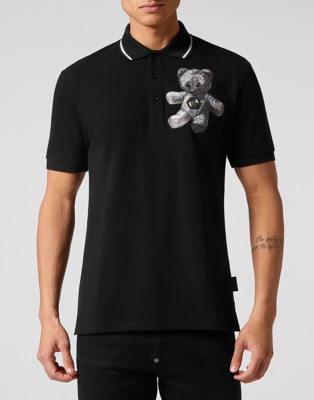 Auch ein Klassiker kann einen alternativen Twist bekommen. Sehen Sie, wie wir das Piqué-Poloshirt revolutioniert haben.    Baumwoll-Piqué   Der kultige Teddybär zusammen mit dem PP-Sechseck auf einem Aufnäher aus Safranleder auf der linken Brustseite   Stoffdetails mit Paisleydruck    Umlegekragen   Rippstrickkragen und -bündchen    Zwei Seitenschlitze