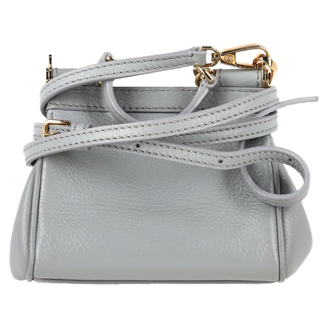 VINTAGE, RRP WIE NEU  
Die Dolce & Gabbana Micro Miss Sicily Top Handle Bag aus grauem Leder ist ein kompaktes Symbol italienischer Eleganz mit einer strukturierten Silhouette und polierter Hardware in Goldoptik. Hergestellt aus geschmeidigem Leder, bietet sie zeitlosen Charme in einer vielseitigen Mikrogröße, die perfekt für den Übergang von Tag zu Nacht ist. Kombinieren Sie sie mit einem einfarbigen Outfit und spitzen Ballerinas für mühelose Raffinesse oder tragen Sie sie crossbody mit einem floralen Kleid für einen verspielten, femininen Akzent.  

Dolce & Gabbana Micro Miss Sicily Top Handle Bag aus grauem Leder  

Zustand: Ausgezeichnet  
Abnutzungserscheinungen: Kein Verkaufsetikett, keine sichtbaren Gebrauchsspuren.  
Verpackung: Keine  
Farbe: Grau  
Material: Leder | Leder  
Größe: Einheitsgröße | Einheitsgröße  
Maße: Breite: 50; Höhe: 130; Länge: 150  
SKU: NAPPUGBBA534102W  