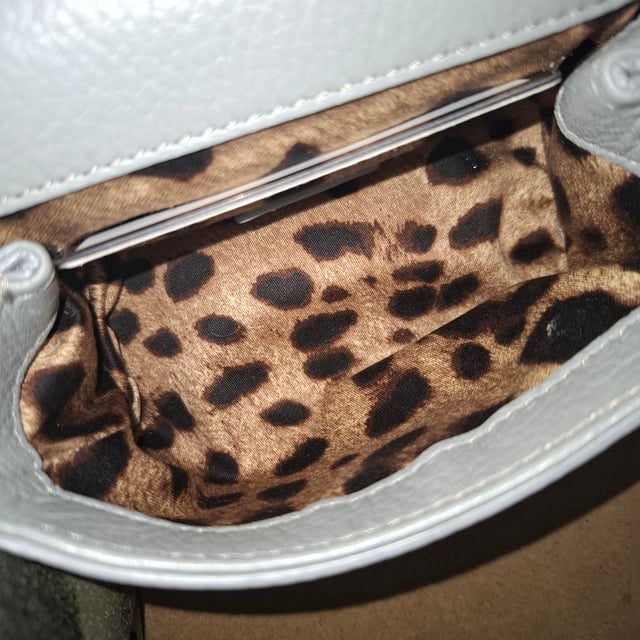 VINTAGE, RRP WIE NEU  
Die Dolce & Gabbana Micro Miss Sicily Top Handle Bag aus grauem Leder ist ein kompaktes Symbol italienischer Eleganz mit einer strukturierten Silhouette und polierter Hardware in Goldoptik. Hergestellt aus geschmeidigem Leder, bietet sie zeitlosen Charme in einer vielseitigen Mikrogröße, die perfekt für den Übergang von Tag zu Nacht ist. Kombinieren Sie sie mit einem einfarbigen Outfit und spitzen Ballerinas für mühelose Raffinesse oder tragen Sie sie crossbody mit einem floralen Kleid für einen verspielten, femininen Akzent.  

Dolce & Gabbana Micro Miss Sicily Top Handle Bag aus grauem Leder  

Zustand: Ausgezeichnet  
Abnutzungserscheinungen: Kein Verkaufsetikett, keine sichtbaren Gebrauchsspuren.  
Verpackung: Keine  
Farbe: Grau  
Material: Leder | Leder  
Größe: Einheitsgröße | Einheitsgröße  
Maße: Breite: 50; Höhe: 130; Länge: 150  
SKU: NAPPUGBBA534102W  