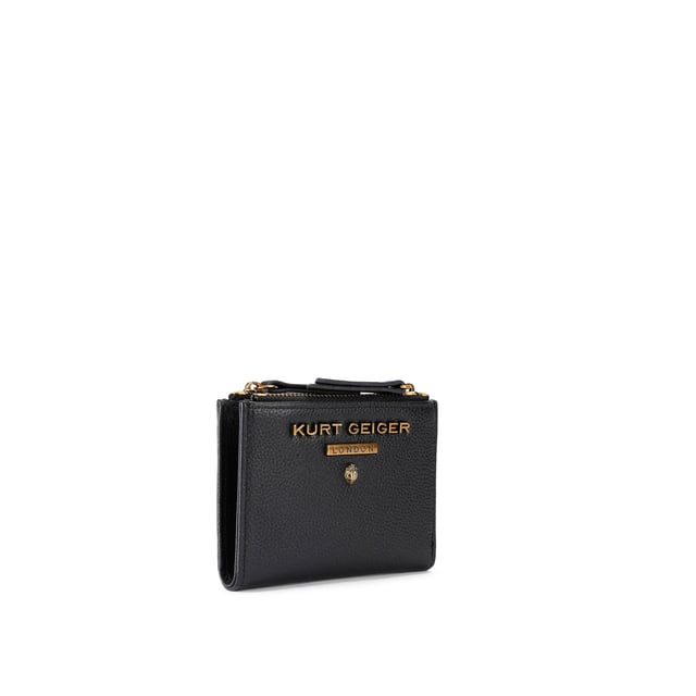 The Greenwich Mini Purse features a black grained leather exterior. There is an antiqued brass eagle head and branding on the front. 9cm (H), 11cm (L), 2cm (D).