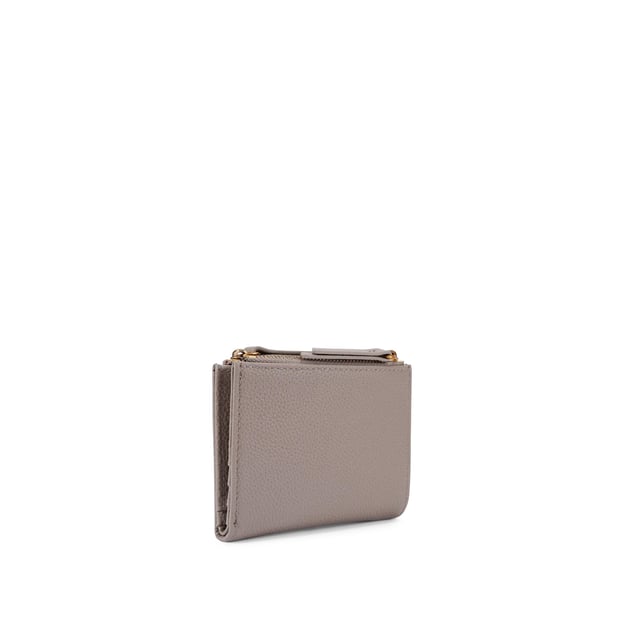 The Greenwich Mini Purse features a taupe grained leather exterior. There is an antiqued brass eagle head and branding on the front. 9cm (H), 11cm (L), 2cm (D).