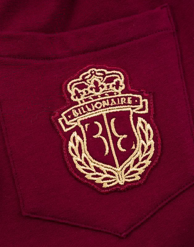 Cotton jersey jogging trousers. Two pockets. Embroidered crest at the back right pocket. Ribbed waistband with drawstring. Snap buttons at bottom.