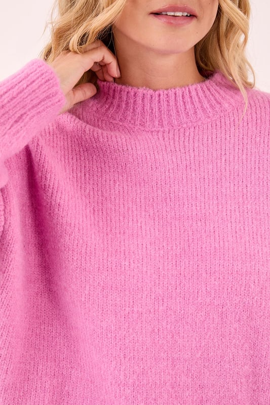 Cosy turtleneck design for ultimate comfort
        Oversized fit with voluminous balloon sleeves
        Ribbed cuffs and hem for a snug finish
        Soft knitted texture for a luxurious feel
        Versatile piece suitable for various casual occasions
    
    Embrace the chilly season with this NastyGal turtleneck sweater, a must-have addition to your autumn-winter wardrobe. The oversized silhouette paired with dramatic balloon sleeves creates a striking visual impact, perfect for those who love to make a statement with their casual wear. Style this jumper with a mini skirt and knee-high boots for a trendy contrast, as seen on our model. For a more laid-back look, pair it with your favourite jeans and trainers. The versatility of this piece makes it ideal for various casual settings, from coffee dates to family gatherings. Layer it over a collared shirt for a preppy twist, or wear it on its own for a sleek, minimalist approach. This turtleneck sweater is your go-to for effortless style and warmth throughout the cooler months.