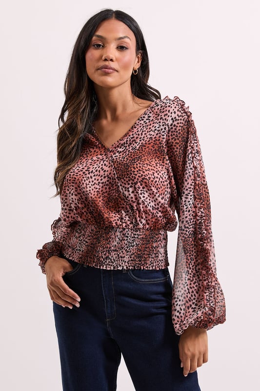 Elegant wrap detail neckline for a flattering silhouette
        Voluminous long sleeves with gentle gathering for a feminine touch
        Shirred elasticated hem creating a stylish cropped profile
        All-over animal print pattern adding contemporary flair
        Lightweight woven fabric offering comfortable wear throughout the day
    
    This Dorothy Perkins Animal Wrap Detail Shirred Hem Top combines sophistication with on-trend styling. The wrap neckline creates a flattering V-shape that frames your dcolletage beautifully without revealing too much, whilst the shirred elasticated hem defines your waist for a figure-enhancing effect. Style with your favourite high-waisted jeans and ankle boots for weekend brunches with the girls, or pair with tailored trousers and ballet flats for family gatherings. The versatile design transitions effortlessly from daytime casual to evening drinks, making it a wardrobe essential for the modern woman who values both style and comfort. Layer with a cardigan and add simple jewellery for a polished finish that works wonderfully for baby showers or informal office settings. This top offers the perfect balance of current fashion trends with timeless wearability.
