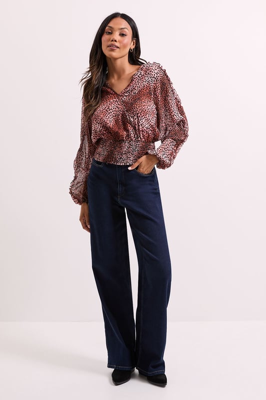 Elegant wrap detail neckline for a flattering silhouette
        Voluminous long sleeves with gentle gathering for a feminine touch
        Shirred elasticated hem creating a stylish cropped profile
        All-over animal print pattern adding contemporary flair
        Lightweight woven fabric offering comfortable wear throughout the day
    
    This Dorothy Perkins Animal Wrap Detail Shirred Hem Top combines sophistication with on-trend styling. The wrap neckline creates a flattering V-shape that frames your dcolletage beautifully without revealing too much, whilst the shirred elasticated hem defines your waist for a figure-enhancing effect. Style with your favourite high-waisted jeans and ankle boots for weekend brunches with the girls, or pair with tailored trousers and ballet flats for family gatherings. The versatile design transitions effortlessly from daytime casual to evening drinks, making it a wardrobe essential for the modern woman who values both style and comfort. Layer with a cardigan and add simple jewellery for a polished finish that works wonderfully for baby showers or informal office settings. This top offers the perfect balance of current fashion trends with timeless wearability.