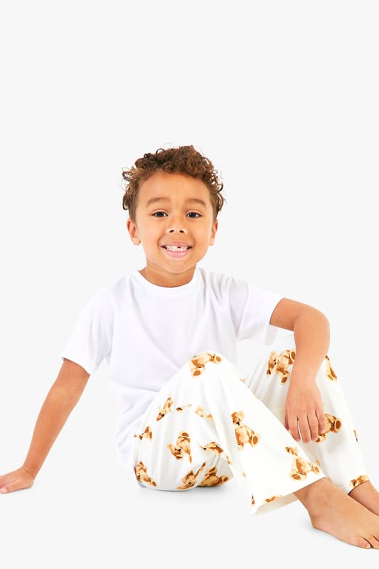 Adorable bear print pyjama bottoms
        Comfortable short-sleeved white top
        Matching set for the whole family
        Relaxed fit for ultimate comfort
        Perfect for festive celebrations
    
    Embrace the holiday spirit with this charming Kinder Br Familien Pyjama-Set from Boohoo. This delightful ensemble features a cosy white short-sleeved top paired with playful bottoms adorned with an enchanting bear print. The relaxed fit ensures maximum comfort for lounging at home or opening presents on Christmas morning. Ideal for creating cherished family moments, this set allows you to coordinate with your loved ones for a picture-perfect holiday look. Whether you're settling in for a festive film night or preparing for Santa's arrival, these pyjamas will keep you feeling snug and stylish. Add a pair of fluffy slippers and a warm dressing gown for those chilly winter evenings, and you're all set for a magical Christmas season.