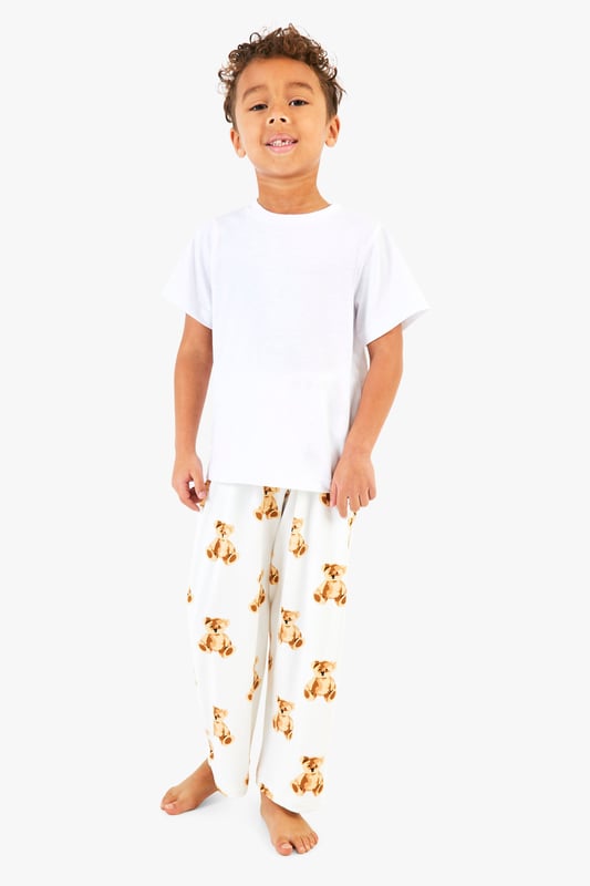 Adorable bear print pyjama bottoms
        Comfortable short-sleeved white top
        Matching set for the whole family
        Relaxed fit for ultimate comfort
        Perfect for festive celebrations
    
    Embrace the holiday spirit with this charming Kinder Br Familien Pyjama-Set from Boohoo. This delightful ensemble features a cosy white short-sleeved top paired with playful bottoms adorned with an enchanting bear print. The relaxed fit ensures maximum comfort for lounging at home or opening presents on Christmas morning. Ideal for creating cherished family moments, this set allows you to coordinate with your loved ones for a picture-perfect holiday look. Whether you're settling in for a festive film night or preparing for Santa's arrival, these pyjamas will keep you feeling snug and stylish. Add a pair of fluffy slippers and a warm dressing gown for those chilly winter evenings, and you're all set for a magical Christmas season.