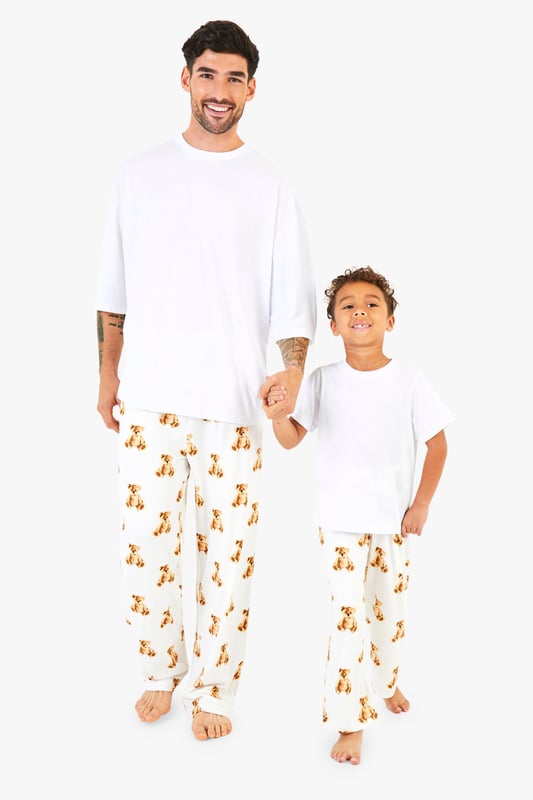 Adorable bear print pyjama bottoms
        Comfortable short-sleeved white top
        Matching set for the whole family
        Relaxed fit for ultimate comfort
        Perfect for festive celebrations
    
    Embrace the holiday spirit with this charming Kinder Br Familien Pyjama-Set from Boohoo. This delightful ensemble features a cosy white short-sleeved top paired with playful bottoms adorned with an enchanting bear print. The relaxed fit ensures maximum comfort for lounging at home or opening presents on Christmas morning. Ideal for creating cherished family moments, this set allows you to coordinate with your loved ones for a picture-perfect holiday look. Whether you're settling in for a festive film night or preparing for Santa's arrival, these pyjamas will keep you feeling snug and stylish. Add a pair of fluffy slippers and a warm dressing gown for those chilly winter evenings, and you're all set for a magical Christmas season.